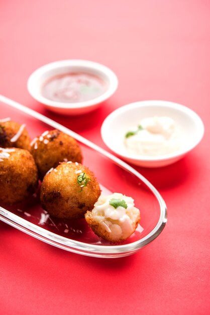 Bolinhas de queijo de batata frita ou croquetes com ketchup de tomate. Foco seletivo