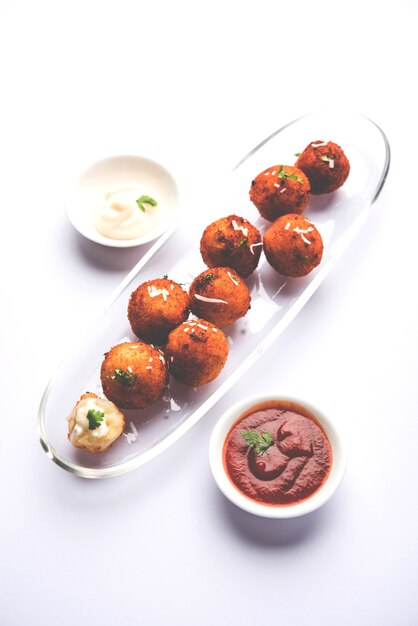 Bolinhas de queijo de batata frita ou croquetes com ketchup de tomate. foco seletivo