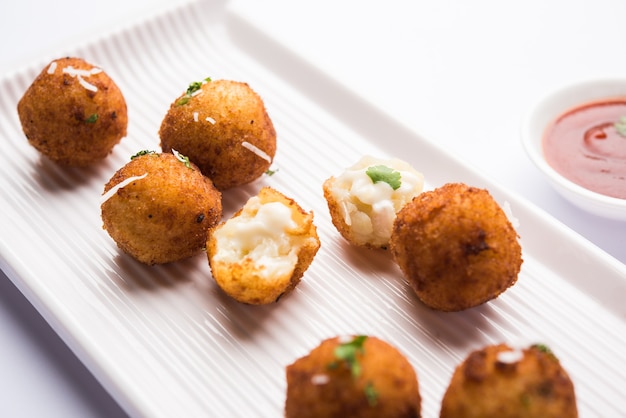 Bolinhas de queijo de batata frita ou croquetes com ketchup de tomate. Foco seletivo