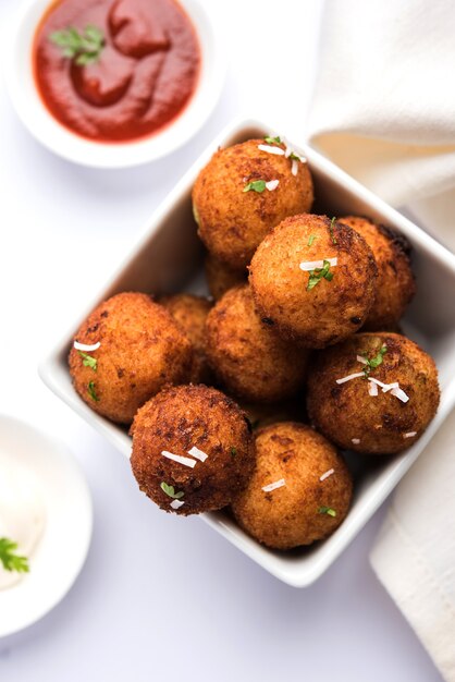 Bolinhas de queijo de batata frita ou croquetes com ketchup de tomate. Foco seletivo