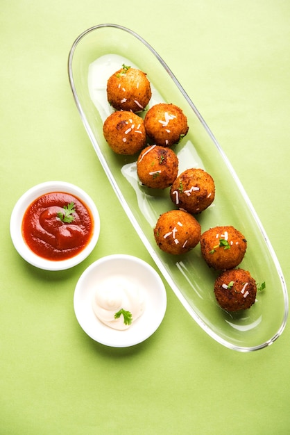 Bolinhas de queijo de batata frita ou croquetes com ketchup de tomate. Foco seletivo