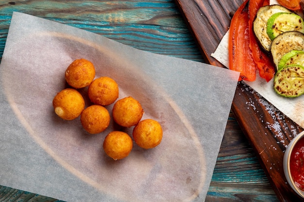 Bolinhas de queijo fritas servidas com molho para o prato principal