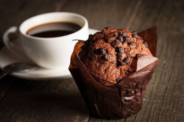 Bolinho cozido escuro de chocolate com hortelã em uma mesa de madeira com canela, anis, chocolate.