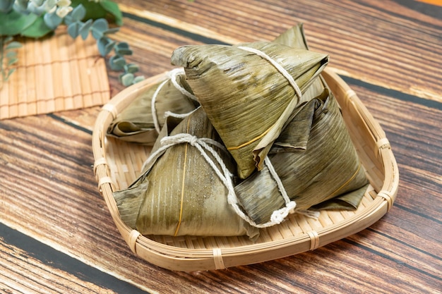 Bolinho de arroz é um prato de arroz tradicional chinês feito de arroz glutinoso e envolto em folhas de bambu Dragon Boat Festival está fazendo e comendo zongzi com a família