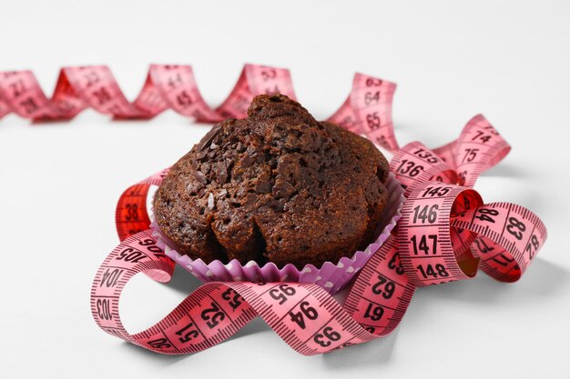 Bolinho de chocolate com centímetro no fundo branco