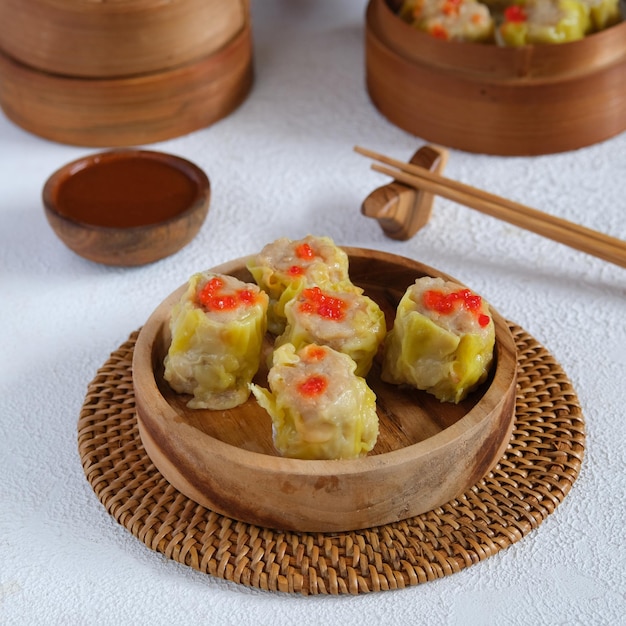 Bolinho de massa chinês ou dimsum no plater de madeira com fundo branco