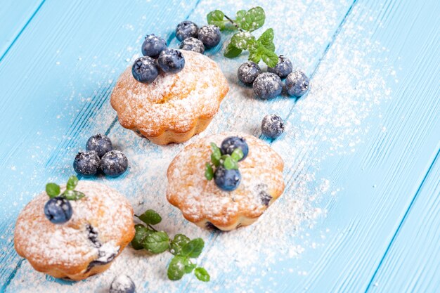 Bolinho de mirtilo. Cupcake assado caseiro com mirtilos, frutas frescas, açúcar em pó