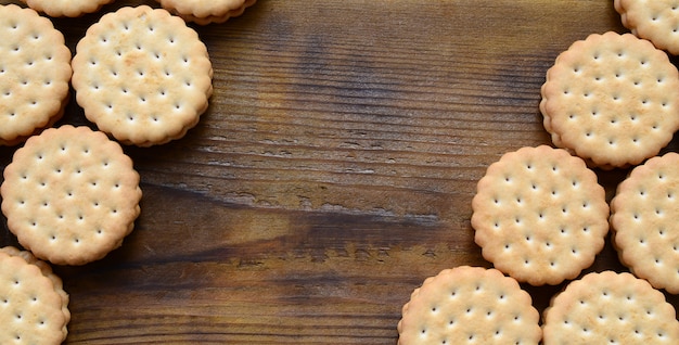 bolinho de sanduíche com recheio de coco encontra-se em grandes quantidades em uma superfície de madeira marrom