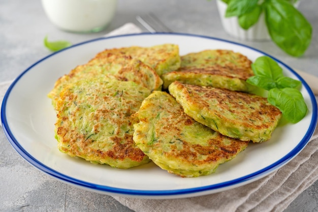 Bolinhos de abobrinha com queijo alho e ervas Panquecas de abobrinha vegetarianas servidas com creme azedo