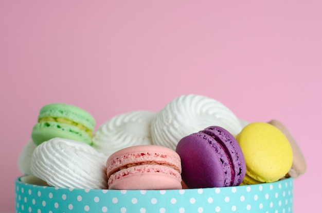 Bolinhos de amêndoa coloridos em uma caixa no rosa pastel. Conceito de cartão de saudação ou convite