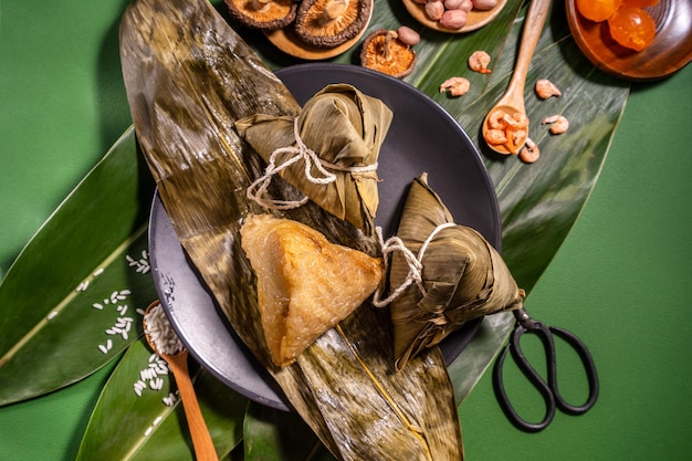 Bolinhos de arroz cozido no vapor Zongzi em comida de fundo de mesa verde no conceito de duanwu do festival do barco dragão fechar espaço de cópia vista superior plana