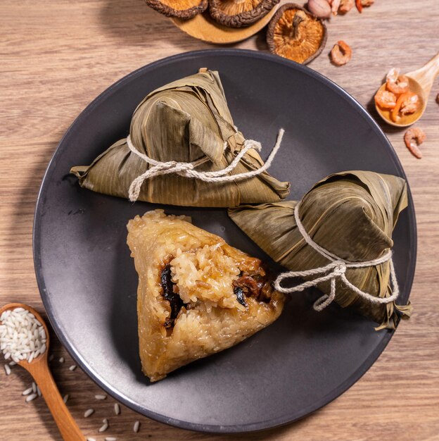 Bolinhos de arroz cozido no vapor Zongzi na mesa de madeira bambu deixa comida no conceito de duanwu do festival do barco dragão fechar espaço de cópia vista de cima