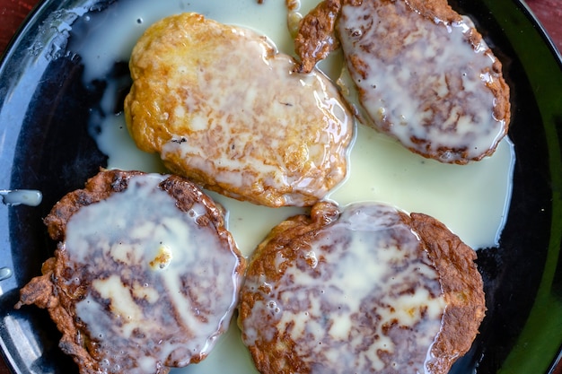 Bolinhos de banana com leite condensado em um prato preto no café da manhã. sobremesa deliciosa, close-up