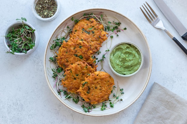 Bolinhos de batata-doce crocantes servidos com microgreens e guacamole