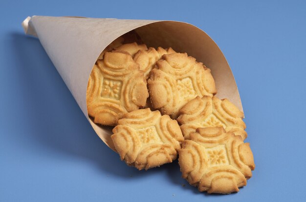 Bolinhos de bolacha em um saco de papel na mesa azul