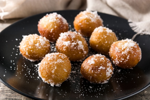 Bolinhos de carnaval ou buñuelos de viento na mesa de madeira