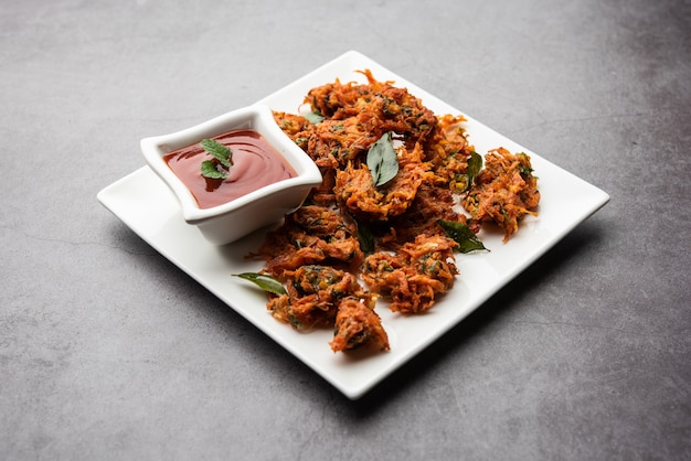 Bolinhos de cenoura ou Gajar ke pakore ou pakode ou bajji ou bhaji, lanche indiano servido em um prato com ketchup de tomate