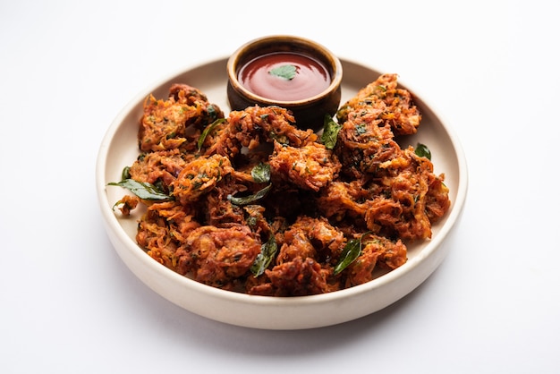 Bolinhos de cenoura ou Gajar ke pakore ou pakode ou bajji ou bhaji, lanche indiano servido em um prato com ketchup de tomate