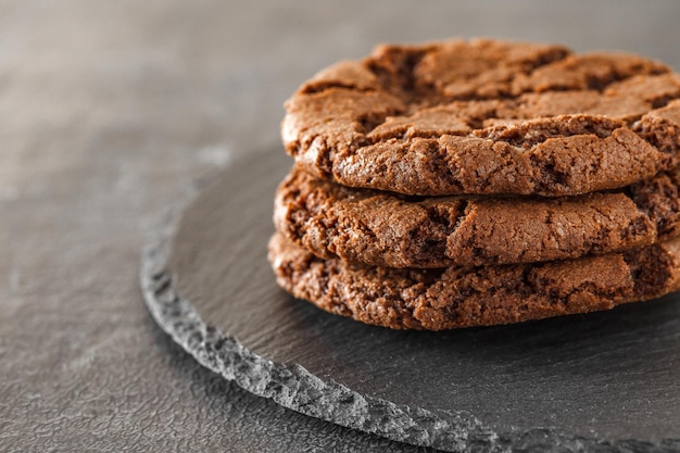 Bolinhos de chocolate castanho farinha de aveia redonda em placa de pedra de ardósia redonda fundo escuro foco seletivo xA