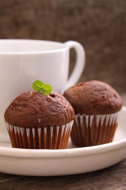 Bolinhos de chocolate com uma xícara de chá em um prato branco