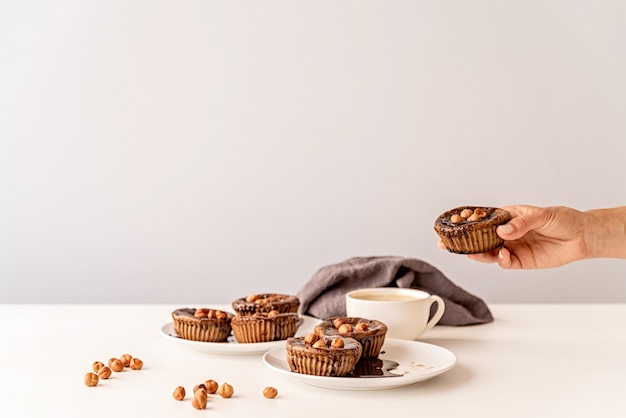 Bolinhos de chocolate com vidros, nozes e uma xícara de café