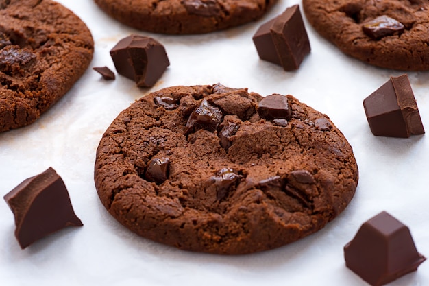 Bolinhos de chocolate e barra de chocolate cozidos macios em papel manteiga