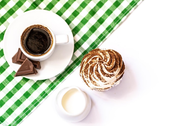 Bolinhos de chocolate escuro e chocolate de cacau com uma xícara de café preto quente em guardanapo verde Espaço para texto