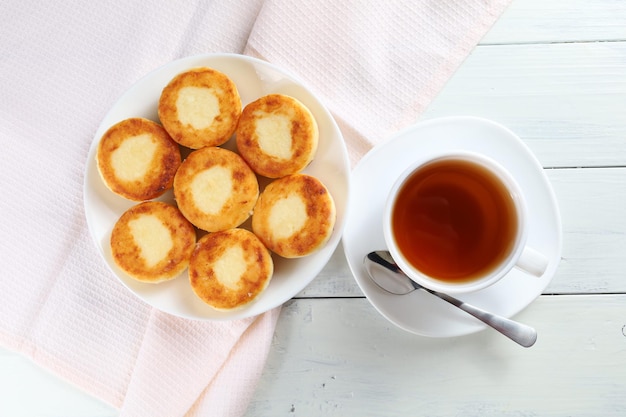 Bolinhos de coalhada com chá Café da manhã tradicional Comida em uma mesa brilhante