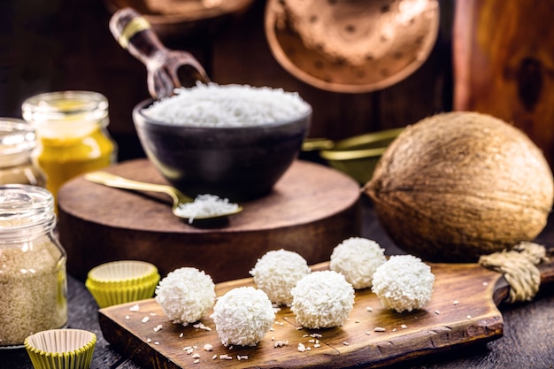 Foto bolinhos de coco, bala de coco com ingredientes de fundo, culinária rústica e saudável