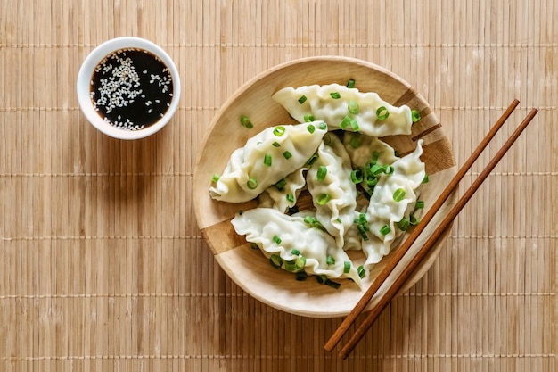 Bolinhos de gyoza cozidos frescos com vapores quentes na placa de madeira