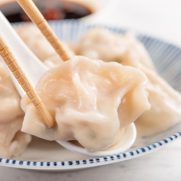 Bolinhos de gyoza de camarão de porco cozido deliciosos frescos em fundo branco com molho de soja e pauzinhos close-up estilo de vida Conceito de design caseiro