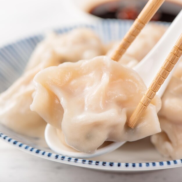 Bolinhos de gyoza de camarão de porco cozido deliciosos frescos em fundo branco com molho de soja e pauzinhos close-up estilo de vida Conceito de design caseiro