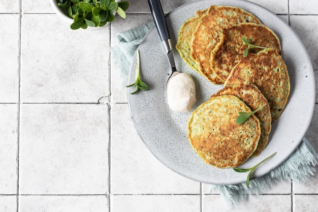 Bolinhos de legumes servidos com ervas frescas e molho Brócolis vegetariano ou panquecas de espinafre