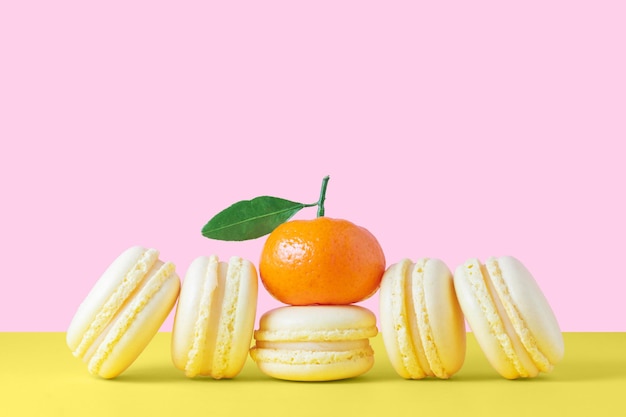 Foto bolinhos de macaroons franceses amarelos com creme de limão sobre fundo amarelo e rosa amor