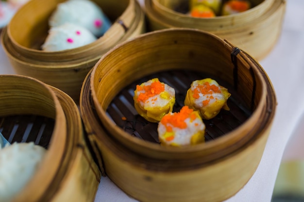 Bolinhos de massa chineses tradicionais de dim sum na cesta de vapor de bambu