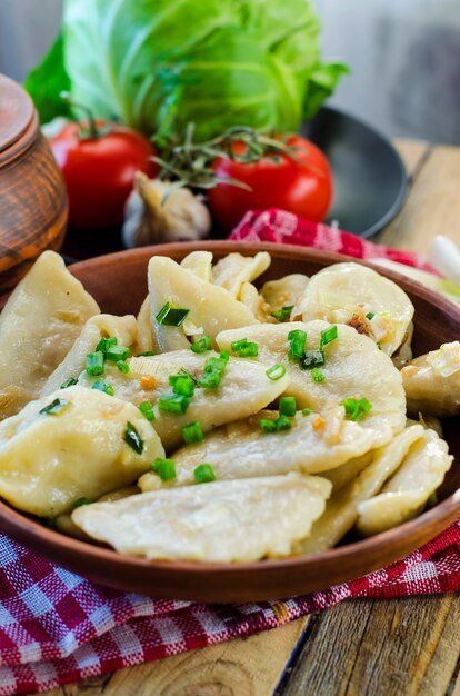 Bolinhos de massa com repolho de batata e carne em um prato de barro