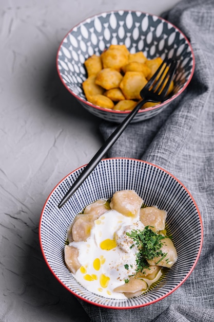 Bolinhos de massa cozidos e fritos com creme de leite e ervas