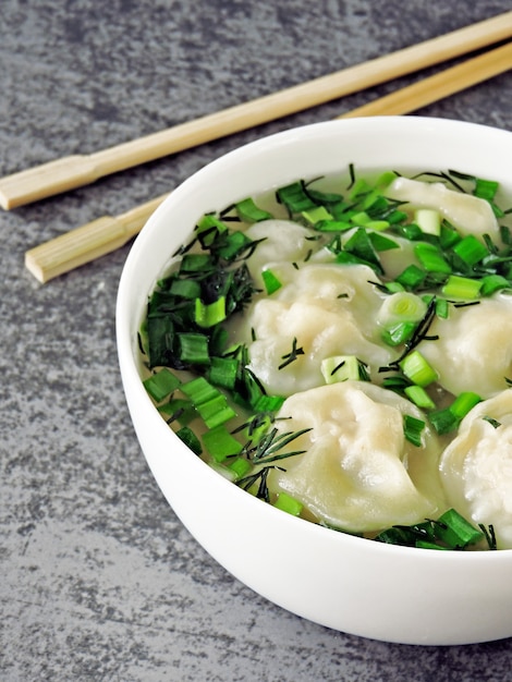 Foto bolinhos de massa em caldo em estilo chinês.