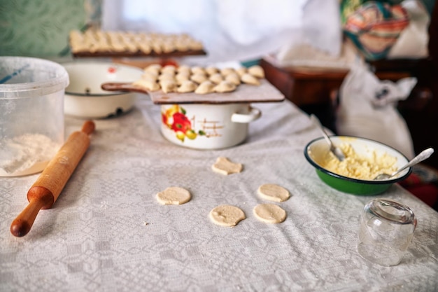 Foto bolinhos de pierogi empilhados lado a lado em uma placa de madeira momentos antes de cozinhar oriente tradicional