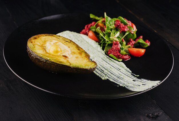 Bolinhos de queijo Bocconcini em metades de abacate servidos com salada