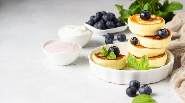 Bolinhos de queijo cottage com mirtilos, hortelã e molho.