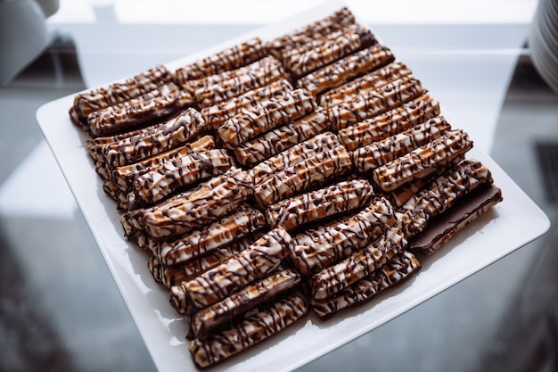 Bolinhos de shortbread regados com chocolate em um prato quadrado branco