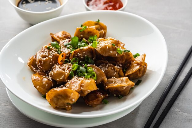 Bolinhos fritos com molho de soja com pimenta e cebola verde. Cozinha asiática