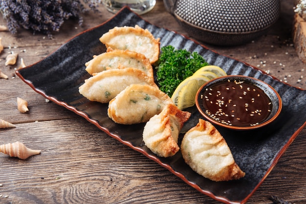 Foto bolinhos japoneses fritos molho gedza mesa de madeira