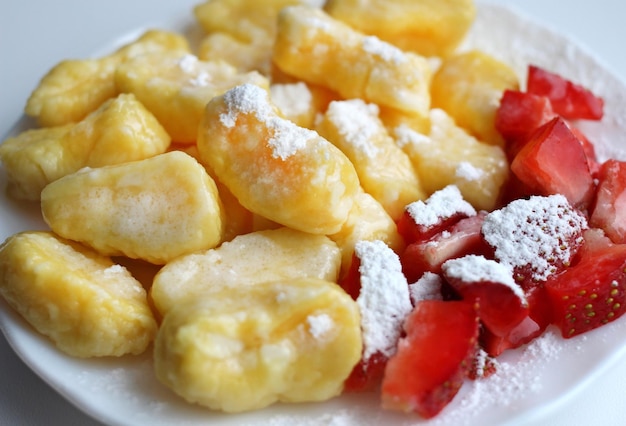 Bolinhos preguiçosos com morangos frescos e açúcar de confeiteiro em um pires branco