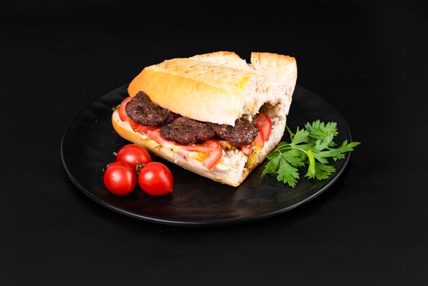 Foto bolitas de carne de pan con tomates y perejil sobre un fondo negro