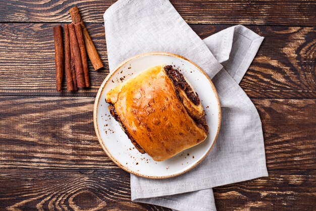 Bollo de canela dulce en mesa de madera