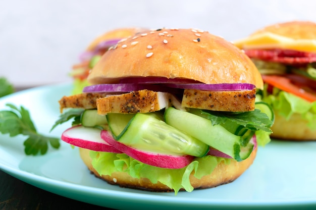 Bollo casero con pechuga de pavo, verduras, hierbas en una tabla de madera. Sandwich para el almuerzo. De cerca