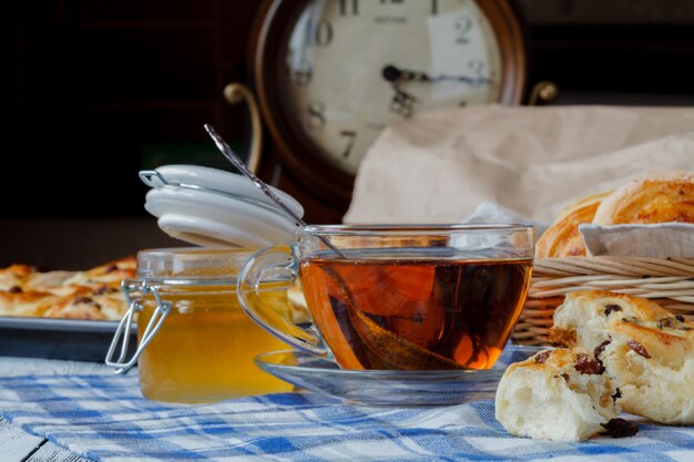 Foto bollo dulce con pasas y una taza de té