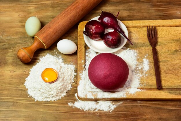 Bollo de masa púrpura para fideos con ingredientes sobre la mesa